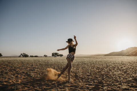 Namibia, Namib-Wüste, Namib-Naukluft-Nationalpark, Sossusvlei, Frau bewegt sich bei Sonnenuntergang an der Elim-Düne, lizenzfreies Stockfoto