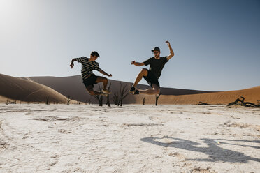 Namibia, Namib-Wüste, Namib-Naukluft-Nationalpark, Sossusvlei, zwei Männer springen im Deadvlei - LHPF00248