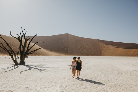 Namibia, Namib-Wüste, Namib-Naukluft-Nationalpark, Sossusvlei, zwei Freundinnen wandern im Deadvlei, lizenzfreies Stockfoto