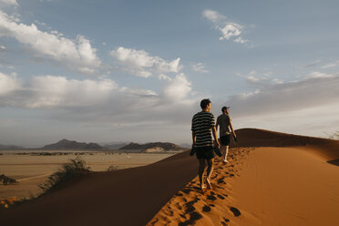 Namibia, Namib desert, Namib-Naukluft National Park, Sossusvlei, two men walking on Elim Dune at sunset - LHPF00254