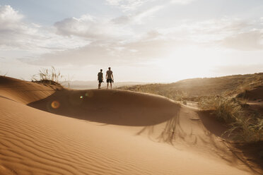 Namibia, Namib-Wüste, Namib-Naukluft-Nationalpark, Sossusvlei, zwei Männer stehen bei Sonnenuntergang auf der Elim-Düne - LHPF00255