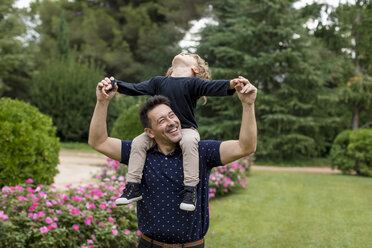 Glücklicher Vater trägt seinen Sohn im Park auf den Schultern - MAUF02078