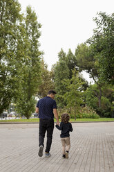 Rear view of father and son walking hand in hand - MAUF02086