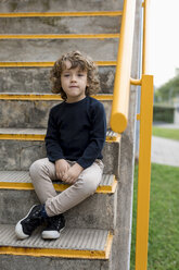 Portrait of boy sitting on stairs - MAUF02096