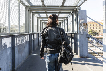 Rückansicht einer jungen Frau, die auf einer Brücke geht - MGIF00276