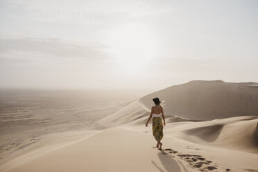 Namibia, Namib, back view of woman walking barefoot on desert dune - LHPF00260