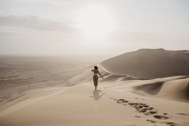 Namibia, Namib, back view of woman standing on desert dune looking at view - LHPF00261