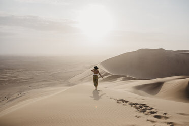 Namibia, Namib, Rückenansicht einer Frau, die auf einer Wüstendüne steht und die Aussicht betrachtet - LHPF00261