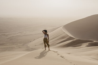 Namibia, Namib, woman standing on desert dune looking at view - LHPF00262