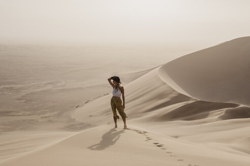 Namibia, Namib, Frau steht auf einer Wüstendüne und betrachtet die Aussicht - LHPF00262