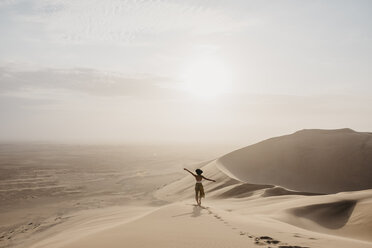 Namibia, Namib, back view of woman standing on desert dune looking at view - LHPF00263
