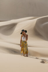 Namibia, Namib, lächelnde junge Frau auf Wüstendüne stehend - LHPF00266