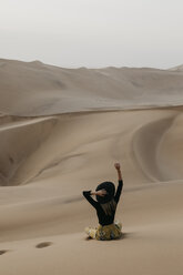 Namibia, Namib, Rückenansicht einer modischen Frau, die auf einer Wüstendüne sitzt - LHPF00273