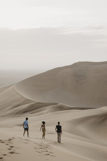 Namibia, Namib, drei Freunde gehen eine Wüstendüne hinunter - LHPF00275