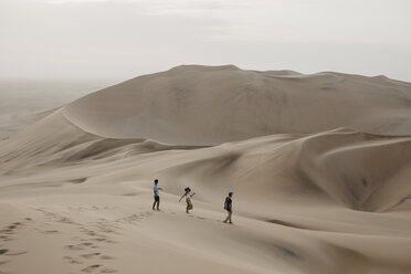 Namibia, Namib, drei Freunde gehen eine Wüstendüne hinunter - LHPF00276