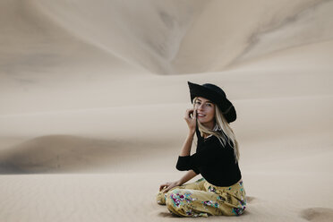 Namibia, Namib, portrait of fashionable woman sitting on desert dune - LHPF00281