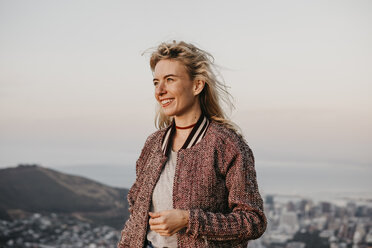 Südafrika, Kapstadt, Kloof Nek, lächelnde Frau an der Küste bei Sonnenuntergang - LHPF00302