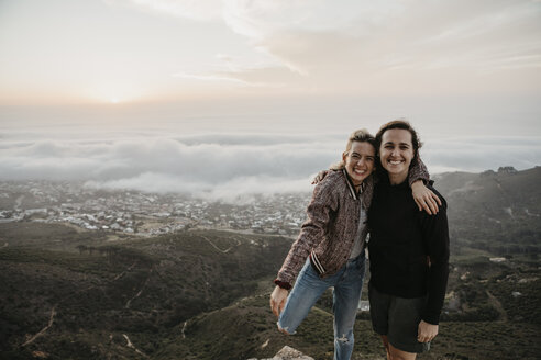 South Africa, Cape Town, Kloof Nek, portrait of two happy women embracing at sunset - LHPF00304