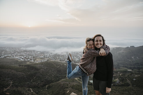 South Africa, Cape Town, Kloof Nek, portrait of two happy women embracing at sunset - LHPF00305