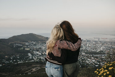 South Africa, Cape Town, Kloof Nek, rear view of two women embracing at sunset - LHPF00306