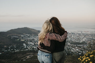 Südafrika, Kapstadt, Kloof Nek, Rückansicht von zwei sich umarmenden Frauen bei Sonnenuntergang - LHPF00306