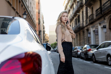 Young businesswoman on cell phone on city street - MAUF02105