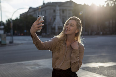 Glückliche junge Frau macht ein Selfie in der Stadt - MAUF02112