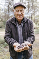 Portrait of smiling senior man showing found mushrooms - JRFF02243