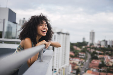 Panama, Panama-Stadt, Porträt einer glücklichen jungen Frau auf einem Balkon - KKAF03096