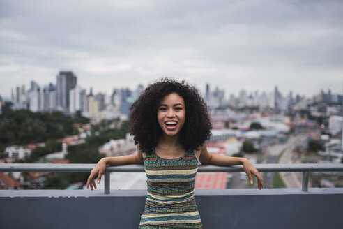 Panama, Panama-Stadt, Porträt einer lachenden jungen Frau auf einem Balkon - KKAF03098