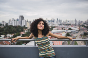 Panama, Panama-Stadt, Porträt einer lachenden jungen Frau auf einem Balkon - KKAF03099