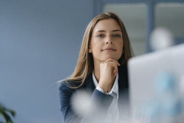 Portrait of a young businesswoman, working in office, using laptop - GUSF01732