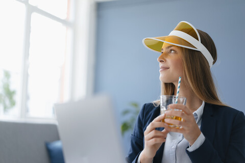 Porträt einer jungen Geschäftsfrau, die im Büro sitzt und von einem Urlaub träumt, lizenzfreies Stockfoto