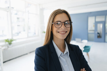 Portrait of a confident young businesswoman, standing in office - GUSF01744