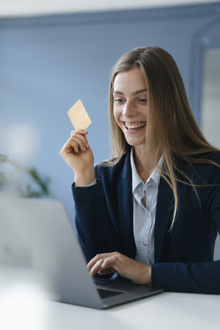 Junge Geschäftsfrau bei einer Online-Zahlung mit ihrer Kreditkarte, lizenzfreies Stockfoto