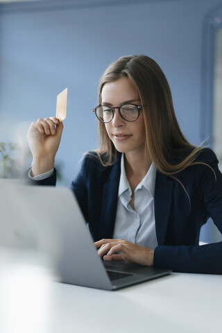 Junge Geschäftsfrau bei einer Online-Zahlung mit ihrer Kreditkarte, lizenzfreies Stockfoto