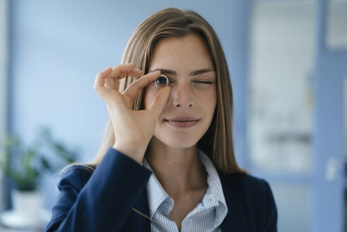 Young businesswoman looking through a wegging ring - GUSF01773