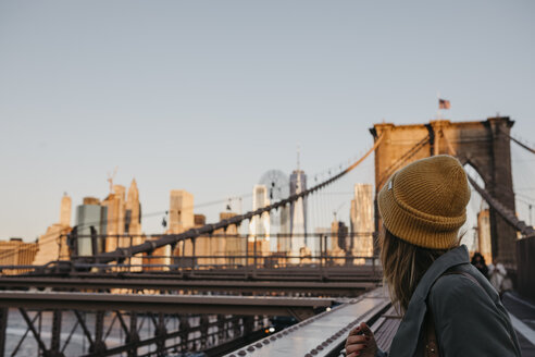 USA, New York, New York City, female tourist on Brooklyn Bridge in the morning light - LHPF00317