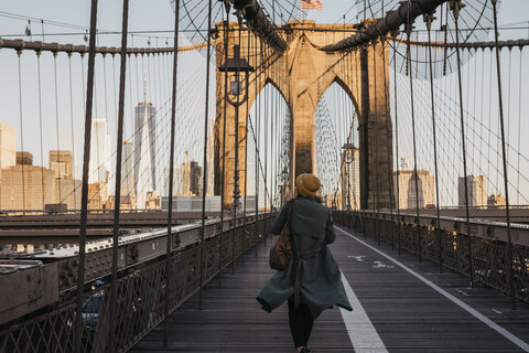 USA, New York, New York City, Touristin auf der Brooklyn Bridge im Morgenlicht, lizenzfreies Stockfoto