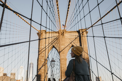 USA, New York, New York City, Touristin auf der Brooklyn Bridge im Morgenlicht, lizenzfreies Stockfoto