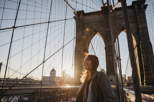 USA, New York, New York City, female tourist on Brooklyn Bridge at sunrise - LHPF00324