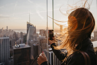 USA, New York, New York City, woman taking a photo at sunrise - LHPF00332