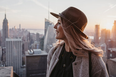 USA, New York, New York City, Portrait of blonde woman with hat at sunrise - LHPF00336