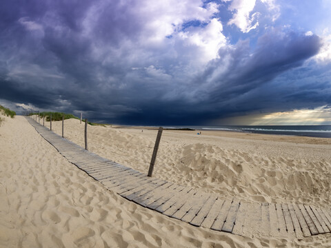 Frankreich, Contis-Plage, Strand und dunkle Wolken, lizenzfreies Stockfoto