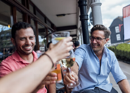 Eine Gruppe von Freunden hat Spaß und stößt auf einer Terrasse an - MGOF03878