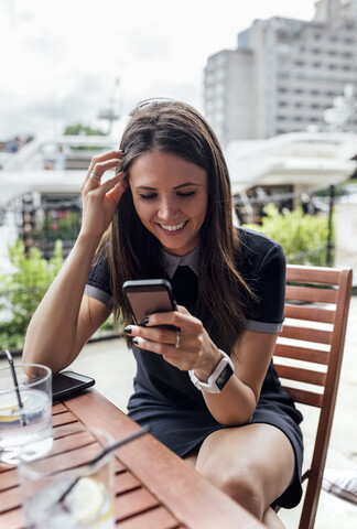 Young beautiful woman using her smartphone on a terrace stock photo