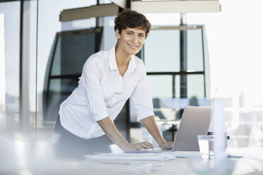 Porträt einer selbstbewussten Geschäftsfrau am Schreibtisch im Büro mit Laptop - RBF06858