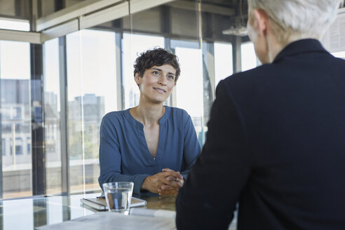 Zwei Geschäftsfrauen im Gespräch am Schreibtisch im Büro - RBF06898