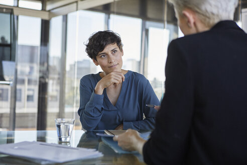 Zwei Geschäftsfrauen im Gespräch am Schreibtisch im Büro - RBF06901