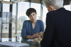 Zwei Geschäftsfrauen im Gespräch am Schreibtisch im Büro - RBF06902